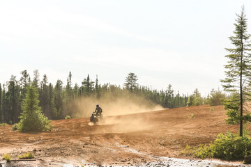Man driving ATV quad in sandy terrain with high speed.