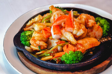 seafood stir-fried with fresh vegetables in a hot pan