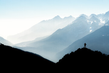 Spectacular mountain ranges silhouettes. Man reaching summit enjoying freedom. View from Top of...