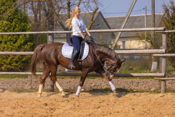 Girl riding a horse gallops in a paddock on a ranch