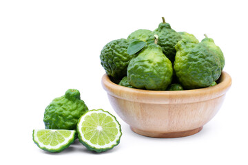 Bergamot or kaffir lime fruits with green leaf in wooden bowl isolated on white background. 