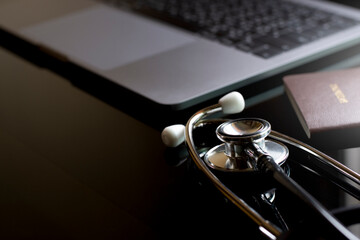 Mockup image of medical stethoscope, passport and laptop computer isolated on dark table...