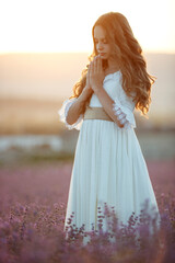 Fototapeta na wymiar Beautiful girl in a field with lavender. High quality photo.