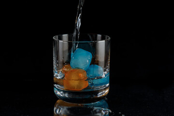 Pouring the drink over the ice cubes