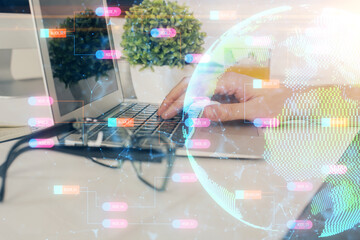 Double exposure of world map hologram with man working on computer on background. Concept of worldwideweb.
