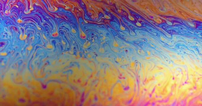 Surface of Liquid Soap with Changing Rainbow Colours. Macro.