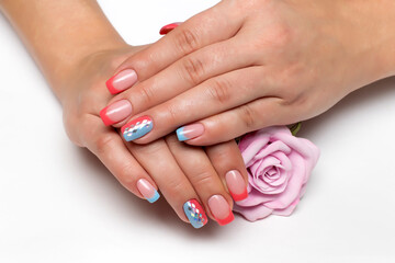 Peach, coral  blue french manicure with silver rhombus on long square nails closeup on a white background with a pink rose in hands