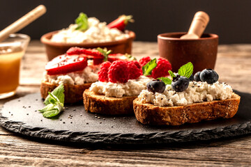 sweet dessert sandwiches with fresh berries blueberry and raspberry, cream cheese, mint and honey, Food recipe background. Close up