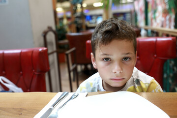 Pensive kid in restaurant