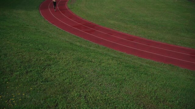 sporty athletic female runner workout outdoor at stadium track