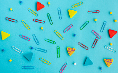 Stationery. Pattern of paper clips and erasers on a blue background..