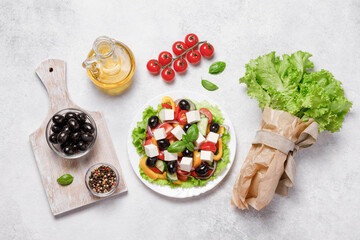 Greek salad with cheese and fresh vegetables on white background.