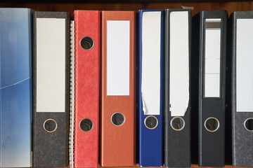 Colored folders for office files and paper on a shelf. Background image. High-quality photo