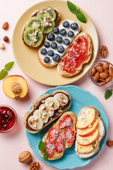 Sweet sandwiches with fruits and berries on pink colorful background.