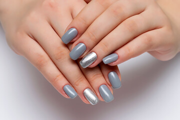 gray manicure with silver sparkles on the ring fingers on square long nails closeup on a white background
 - obrazy, fototapety, plakaty