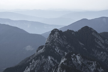 Spectacular view of grey mountain ranges silhouettes and fog in valleys. Julian Alps, Triglav...