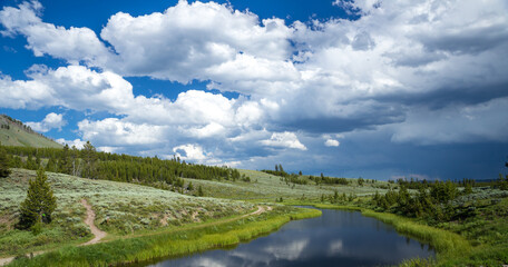 Fototapeta na wymiar Calm river under cloudy sky in Yellowstone national park