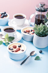 Berry clafouti. Traditional french sweet fruit dessert clafoutis with raspberries and blueberries on blue pink background. Healthy gluten free food concept with copy space. Retro style toned.