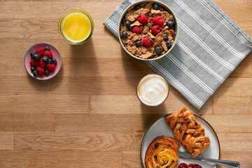 Overhead Flat Lay Shot Of Table Laid For Breakfast With Cereal Pastries And Coffee