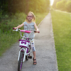 Obraz na płótnie Canvas little girl riding a bicycle