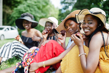 Group of african american girls celebrating birthday party and eat muffins outdoor with decor.