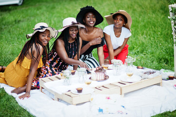 Group of african american girls celebrating birthday party and cutting cake outdoor with decor.