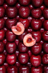 Fresh sweet cherry halves of a berry in the center. Creative art pattern wallpaper.