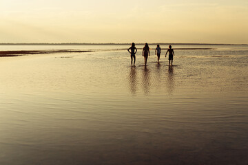 Fototapeta na wymiar children walking on the beach at sunset