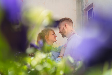 young couple is spending time on a balcony of their flat.  couple smiling and spending leisure time together. man and woman holding each other