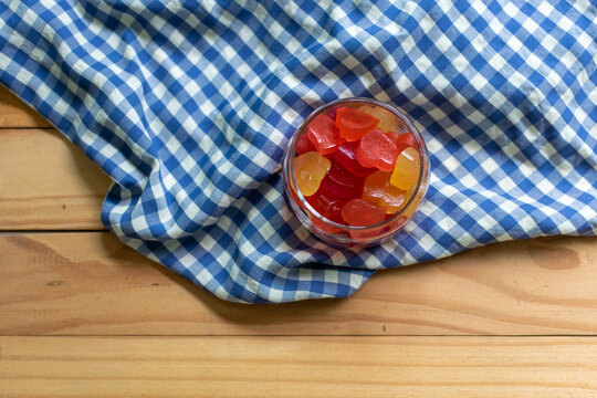 Colorful Heart form Jelly in the Glass Jar on the Wooden Table Decorate with Scottish Pattern Fabric