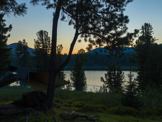 Evening on the forest lake. Darkness descends on a tourist camp. Night in the wild