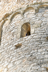 Ventana del antiguo castillo medieval con elevados muros construido sobre rocas en la población de Calafell.