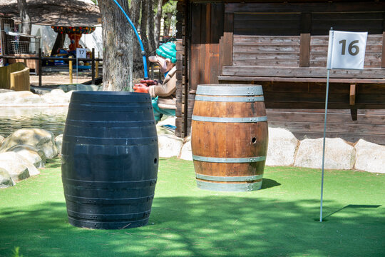 Obst&aacute;culo creado con barriles para acertar en el hoyo 16 en el campo de minigolf.