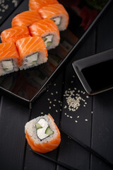 Traditional fresh Japanese Philadelphia sushi rolls on a black wooden background