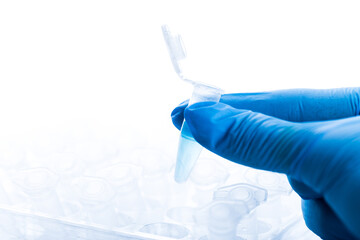 gloved hand and laboratory test tubes in a laboratory. virus or vaccine testing