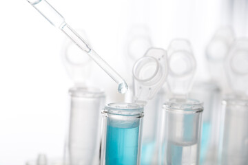 microbiological pipette in the genetic laboratory. study of a virus or vaccination. blue tinted.