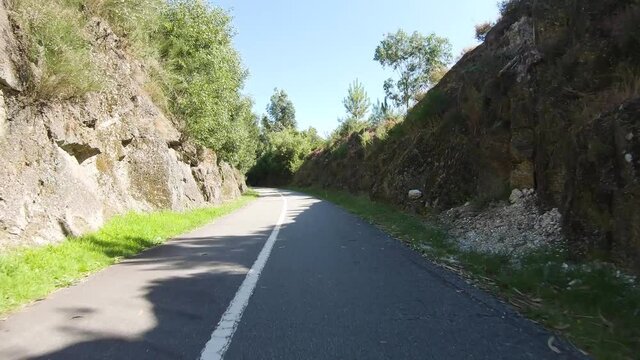 Point of view shot of riding a bicycle at Guimar&atilde;es-Fafe Cycling Trail in Portugal. Features a wide view of the bike track and the natural scenery as it travels.