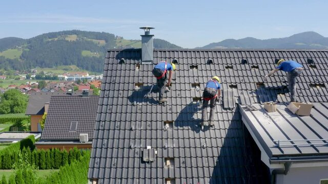 group of installers of solar panels setting up the rails on the roof