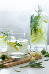 Refreshing iced drink with lemon and fresh rosemary, detox summertime