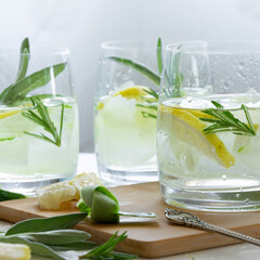 Refreshing iced drink with lemon and fresh rosemary, detox summertime