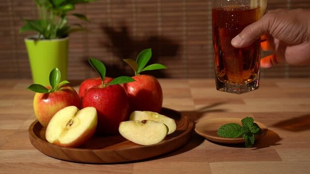 Apple juice. Slow motion shot of place the apple juice glass on the coasters.