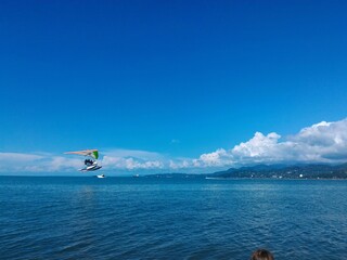 Kite surfing on the sea. Blue bright sky background.