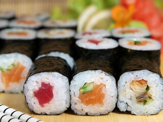Japanese set of maki rolls with tuna, salmon and eel on a wooden tray close-up