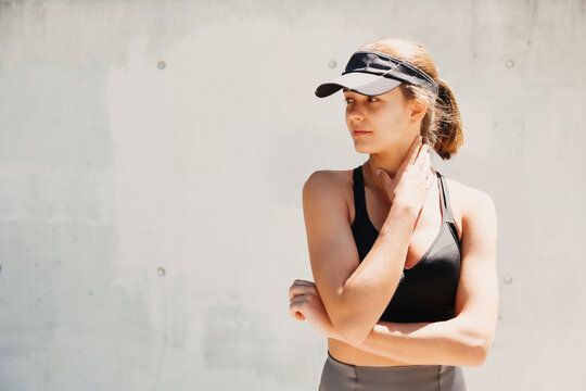 Portrait of a beautiful young sporty woman with visor cap in a hot day