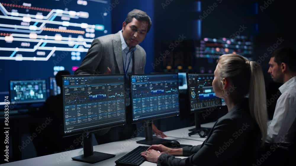 Poster confident female specialist works on computer talks with team leader in big infrastructure control r