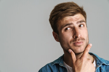 Portrait of redhead puzzled man posing and thinking at camera