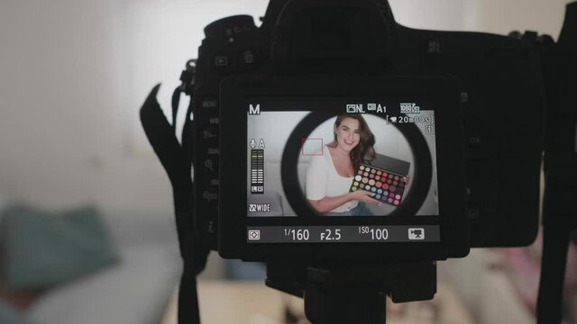 Fashion blogger presenting makeup cosmetics at home. Influencer in the concept of social media.