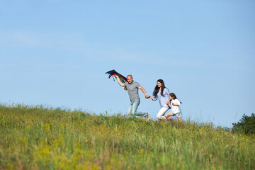 happy family with child girl playing with colorful kite outdoor