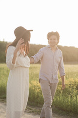 Young couple walking together hand by hand in countryside. Soft selective focus.