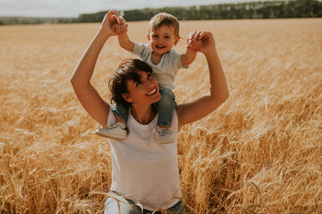 mother and son sitting in a wheat field